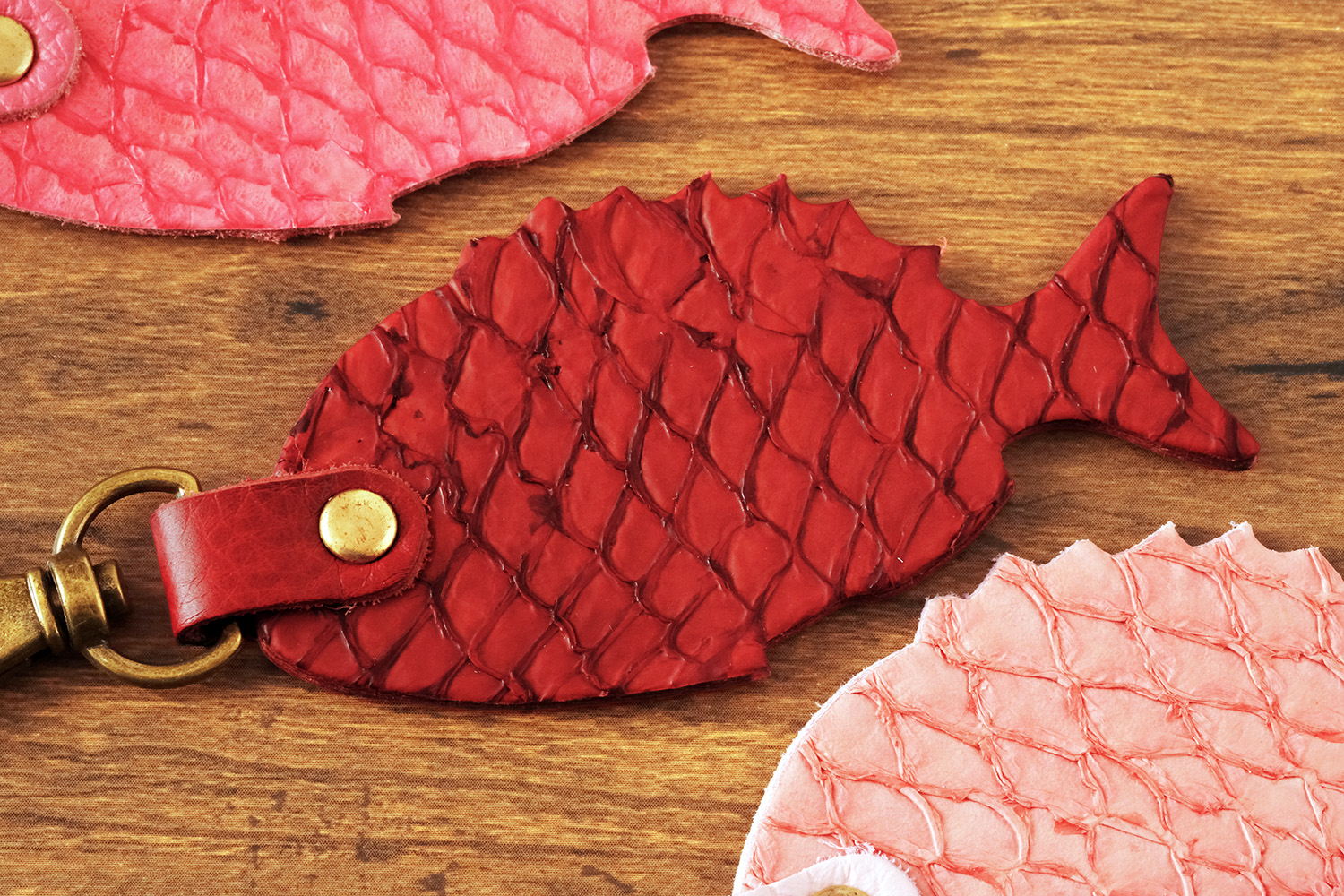 「HAPPY ANGLER リアル魚皮キーホルダー」の「シェイプ：マダイ」の写真。3種類のカラーが並んでいる。
