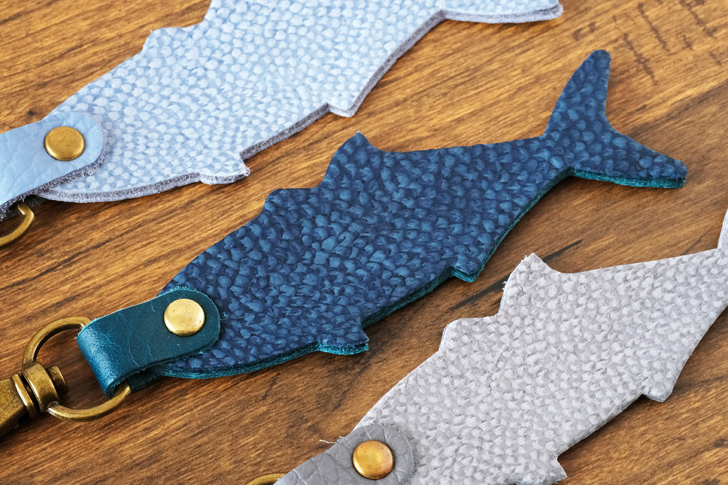 「HAPPY ANGLER リアル魚皮キーホルダー」の「シェイプ：ブリ」の写真。3種類のカラーが並んでいる。