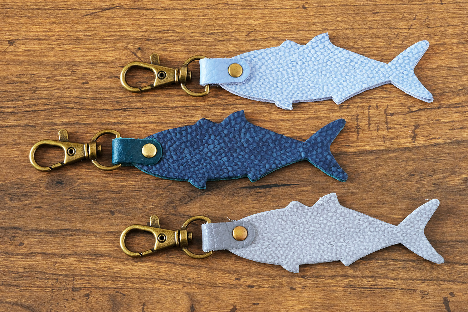 「HAPPY ANGLER リアル魚皮キーホルダー」の「シェイプ：ブリ」の写真。3種類のカラーが並んでいる。